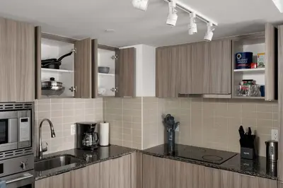 a kitchen with brown cabinets and a counter top at Modern 1BR Condo by Yorkville w Sofa Bed Sleeps 3 in Toronto