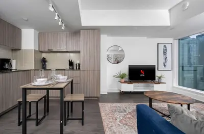 a living room with a table and a kitchen at Modern 1BR Condo by Yorkville w Sofa Bed Sleeps 3 in Toronto