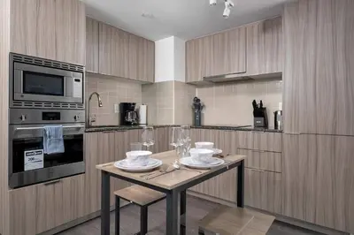 a kitchen with a table with plates and wine glasses at Modern 1BR Condo by Yorkville w Sofa Bed Sleeps 3 in Toronto
