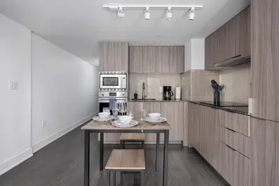 a kitchen with a wooden table in a room at Modern 1BR Condo by Yorkville w Sofa Bed Sleeps 3 in Toronto