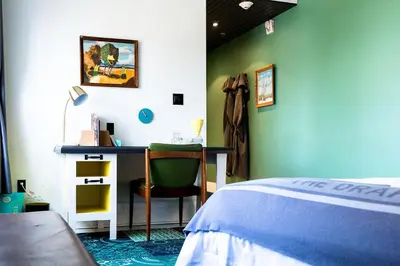 a bedroom with a bed and a desk with a chair at Drake Devonshire and Motor Inn in Wellington
