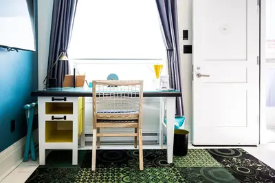 a desk with a chair in a room with a window at Drake Devonshire and Motor Inn in Wellington