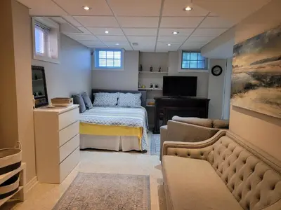 a bedroom with a bed and a television and a couch at Cozy and comfy Studio Apartment in Richmond Hill