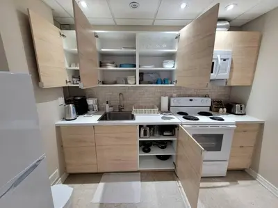 a kitchen with wooden cabinets and a white stove top oven at Cozy and comfy Studio Apartment in Richmond Hill
