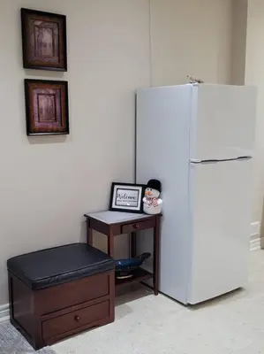 a desk with a white refrigerator in a room at Cozy and comfy Studio Apartment in Richmond Hill