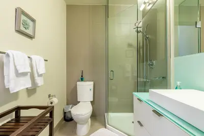 a bathroom with a toilet and a glass shower at Modern Suite w City Views - Downtown in Toronto