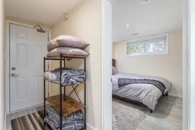 a bedroom with a bed and a stack of pillows at Bright & Modern 1 bedroom unit! in Guelph