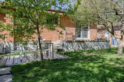 a building with chairs and a tree in the yard at Bright & Modern 1 bedroom unit! in Guelph