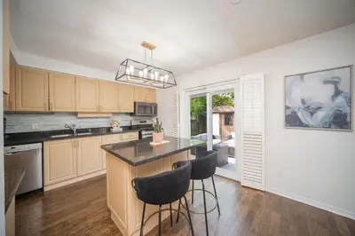a kitchen with a island with bar stools at Peaceful Heartland KingBed Workstation BackyardFun in Mississauga