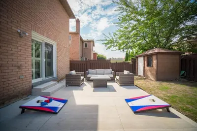 a patio with a couch and a table and chairs at Peaceful Heartland KingBed Workstation BackyardFun in Mississauga