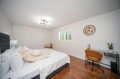 a white bedroom with a bed and a chair at Peaceful Heartland KingBed Workstation BackyardFun in Mississauga