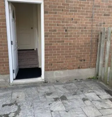a brick building with a white door and a brick wall at Full Privacy Entire basement,kitchen,1parking in Oshawa