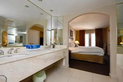 a bathroom with two sinks and a bedroom with a bed at Relaxing 2BR Retreat at Carriage Hills in Edgar