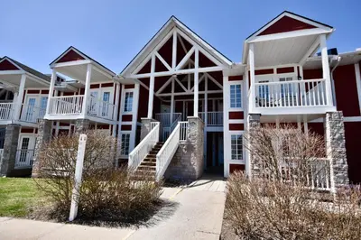 a large apartment building with white balconies and stairs at Relaxing 2BR Retreat at Carriage Hills in Edgar