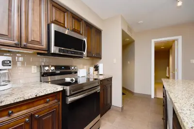 a kitchen with a stove and a microwave at Jacuzzi Suite with King bed, full kitchen in Shanty Bay