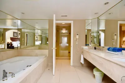 a bathroom with a tub and two sinks and mirrors at Jacuzzi Suite with King bed, full kitchen in Shanty Bay