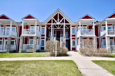 a large red and white house with a sidewalk at Jacuzzi Suite with King bed, full kitchen in Shanty Bay