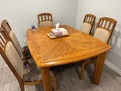 a wooden table with chairs and a box of tissues on it at 1 bedroom cozy apartment in Kitchener