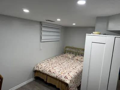 a small bedroom with a bed and a window at 1 bedroom cozy apartment in Kitchener