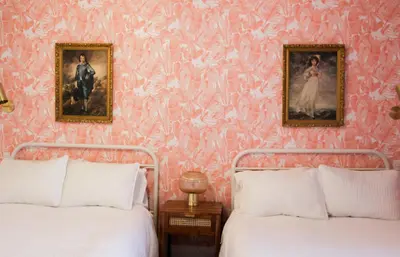 two beds in a room with pink wallpaper at Boutique Accommodation in PEC - Suite 4 in Belleville