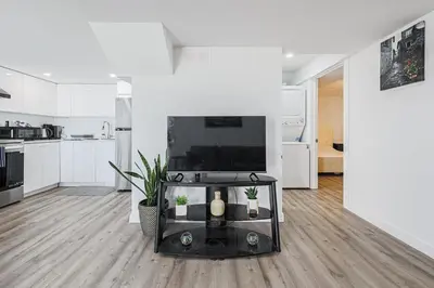 a white living room with a flat screen tv at Exquisite 2-Bdrm Basement Suite with FREE Parking in Bradford
