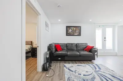 a living room with a gray couch and red pillows at Exquisite 2-Bdrm Basement Suite with FREE Parking in Bradford