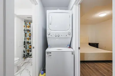 a kitchen with a washer and dryer in a room at Exquisite 2-Bdrm Basement Suite with FREE Parking in Bradford