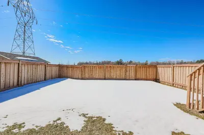 a backyard with a wooden fence and snow at Exquisite 2-Bdrm Basement Suite with FREE Parking in Bradford