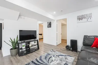 a living room with a couch and a flat screen tv at Exquisite 2-Bdrm Basement Suite with FREE Parking in Bradford