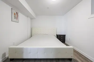 a white bed in a white room with a white mattress at Exquisite 2-Bdrm Basement Suite with FREE Parking in Bradford