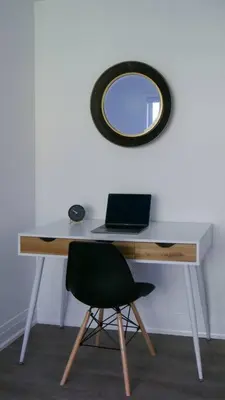 a desk with a mirror and a laptop and a chair at Spacious 3 Bdrm Retreat, Muskoka Room & Fireplace in Bracebridge