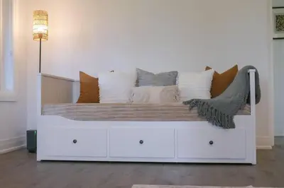 a white bed with pillows on it in a room at Spacious 3 Bdrm Retreat, Muskoka Room & Fireplace in Bracebridge