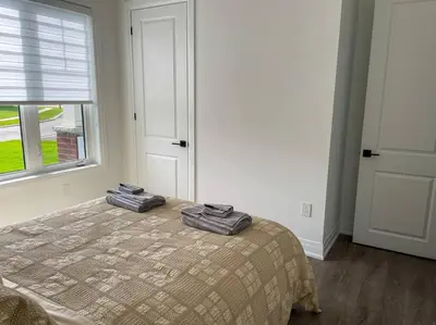 a bedroom with a bed with two towels on it at Spacious 3 Bdrm Retreat, Muskoka Room & Fireplace in Bracebridge
