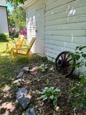 a yard with a chair and a bench next to a building at Charming Farmhouse in the City, Near Wine Country in Belleville