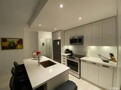 a kitchen with white cabinets and a white counter top at Beautiful Condo, 2 Bedrooms and a Den in Friday Harbour Resort! in Innisfil