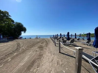 a row of chairs on a beach with the ocean at Beautiful Condo, 2 Bedrooms and a Den in Friday Harbour Resort! in Innisfil