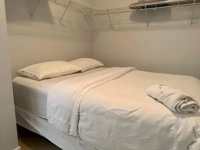 a white bed with white sheets and pillows at Cityview in the Sky 2Bdrms 2Baths 5realbeds in Toronto