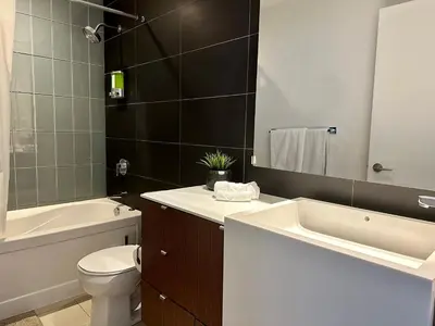 a bathroom with a toilet and a sink and a bath tub at Cityview in the Sky 2Bdrms 2Baths 5realbeds in Toronto