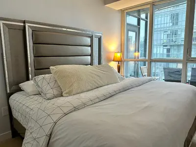 a bedroom with a large bed with a large window at Cityview in the Sky 2Bdrms 2Baths 5realbeds in Toronto