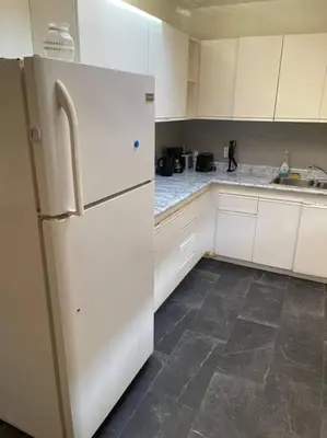 a kitchen with white cabinets and a white refrigerator at Quaint and Cozy Haven in Toronto