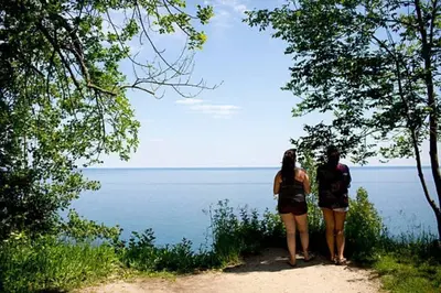 two people standing on a trail looking at the water at Quaint and Cozy Haven in Toronto