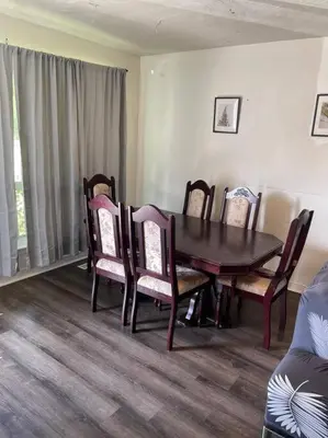 a dining room with a wooden table and chairs at Quaint and Cozy Haven in Toronto