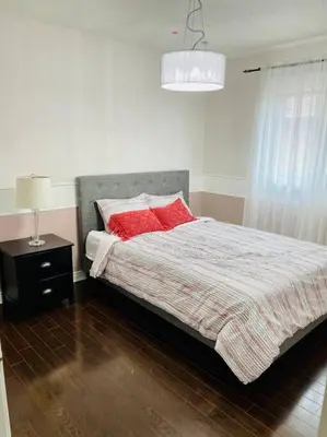 a bedroom with a bed with red pillows on it at Three bedroom house in Mississauga