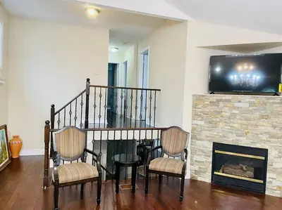 a living room with two chairs and a fireplace at Three bedroom house in Mississauga