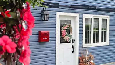 a blue house with a white door and a mailbox at Luxury Family House 3 beds, 1 bath, 5 guest in Toronto