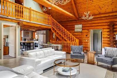 a living room with white furniture and a wooden ceiling at Forest Hideaway in Hespeler