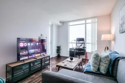 a living room with a couch and a flat screen tv at Rivetstays- The Neptune I in Toronto