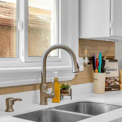 a kitchen sink with a faucet next to a window at Retro Arcade & Gaming Home by Pako Stays in Brampton