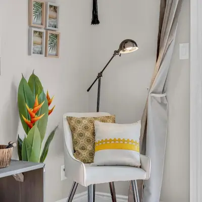 a white chair with a pillow and a lamp at Retro Arcade & Gaming Home by Pako Stays in Brampton