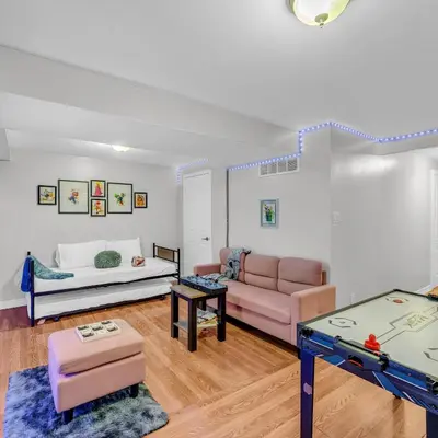 a living room with a couch and a table at Retro Arcade & Gaming Home by Pako Stays in Brampton